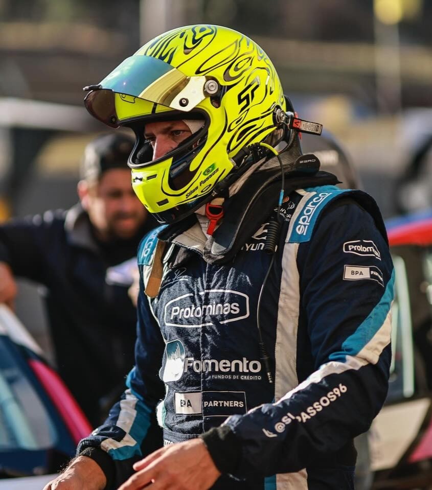 Silas Passos em traje de corrida ao lado do carro